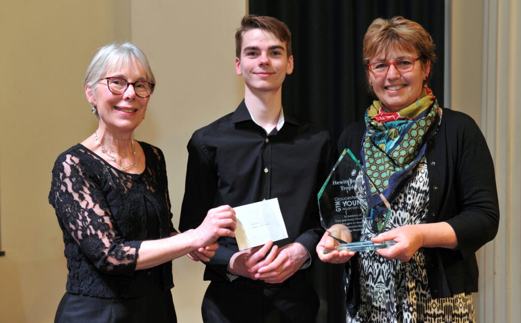 WINNER Isaac Williams receives his cheque from Brimpsfield Music Society's Sara Harris and the Hewitt-Jones trophy from Caroline Lumsden. Photo Mikal Ludlow